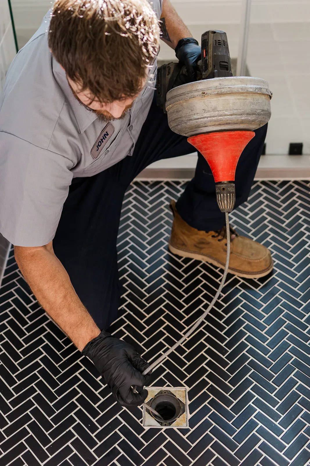 Underwood plumber clearing a floor drain